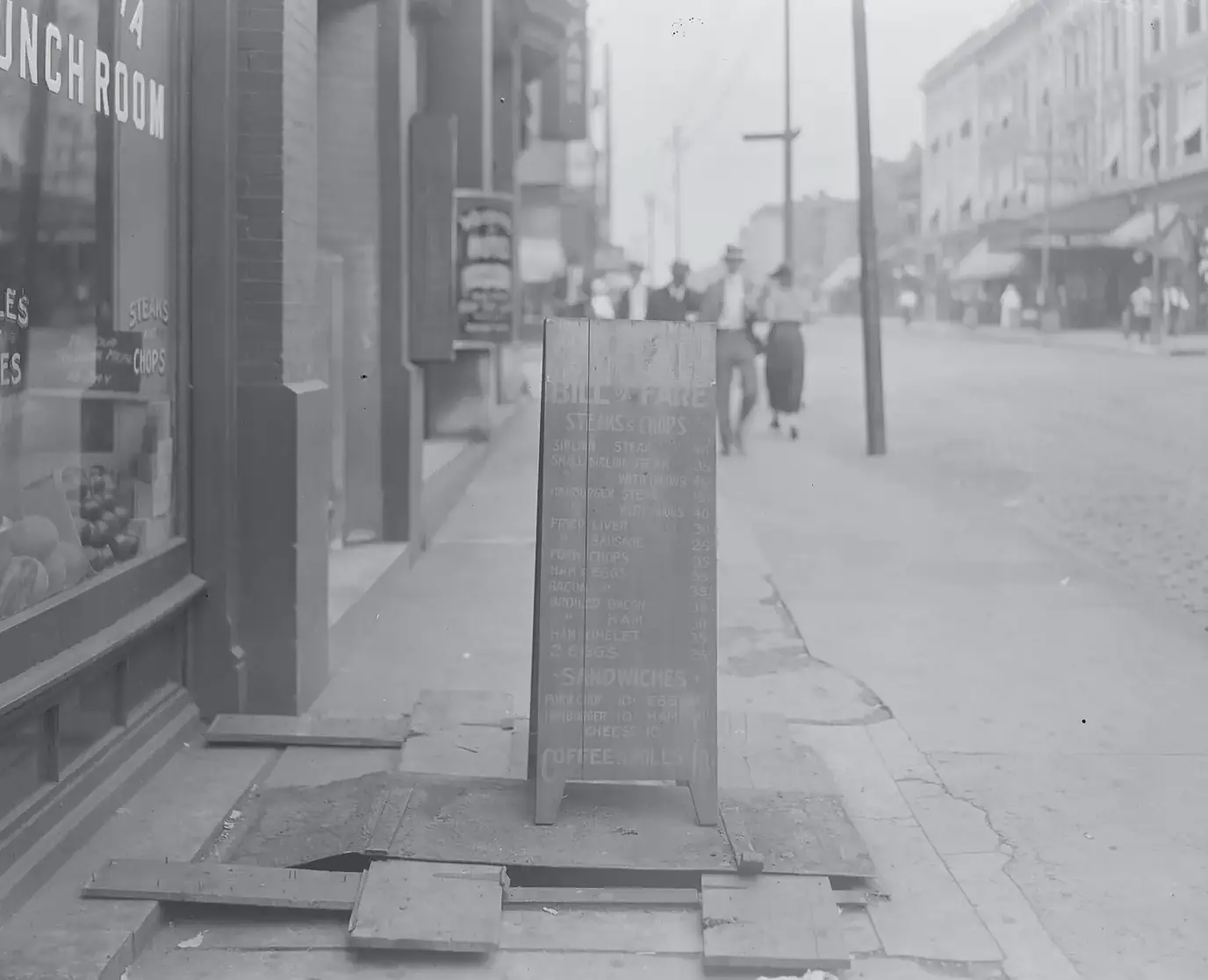 A chalk menu board outside a lunch room on Market Street, St. Louis, around 1920